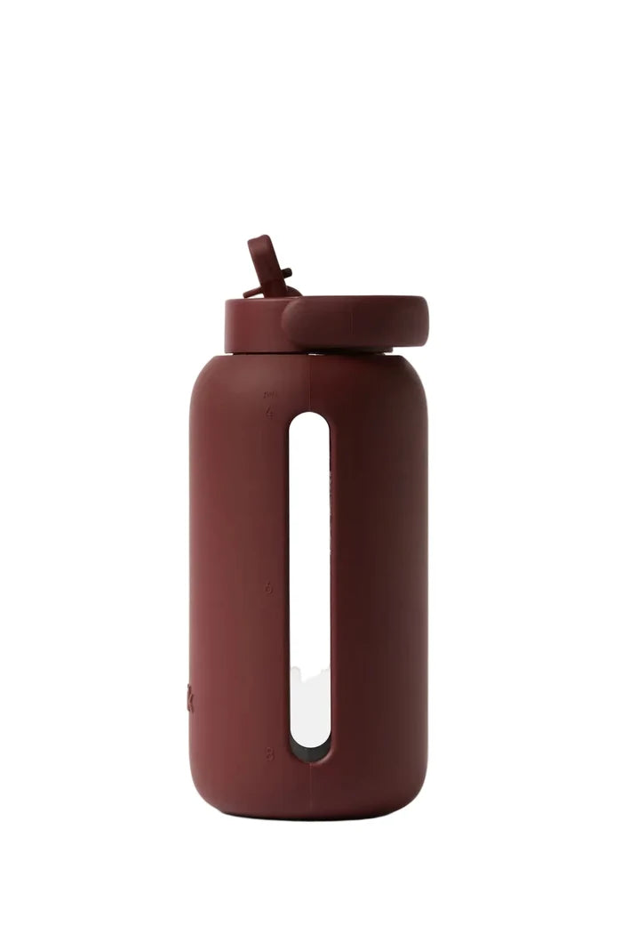 Brown water bottle with a straw on a white background