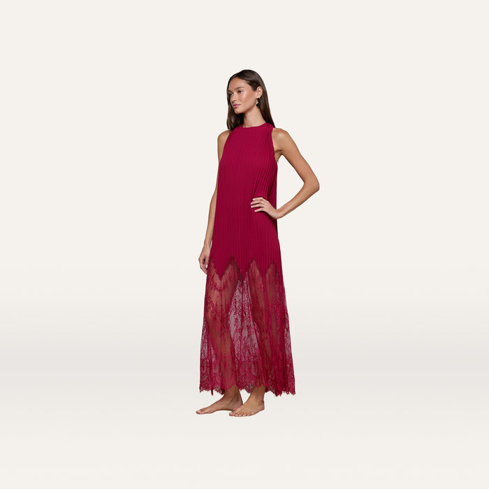 A woman stands barefoot wearing the Adalynn Cover-Up Dress, a sleeveless, floor-length red chiffon piece featuring a sheer lace hem. She poses with one hand on her hip against a plain white background.