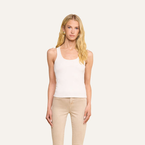 A woman with long blonde hair wearing the Adira Scoopneck Tank and beige pants stands facing forward against a plain light background.