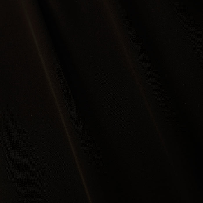 A close-up of black sheer chiffon fabric with subtle folds and soft diagonal shadows, perfect for the elegant Adonis Cover-Up Pant or a chic poolside look.