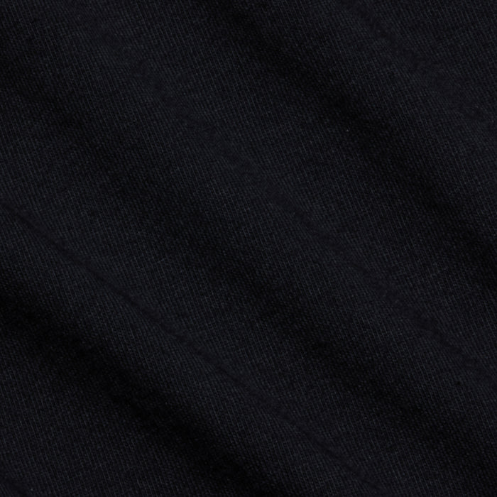 Close-up of black Supima cotton fabric from the Aileen Cotton Crewneck Tee, featuring subtle diagonal lines and fine ribbing that create a soft, uniform pattern. The lighting accentuates its smooth and slightly matte surface.