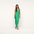 A woman wearing the Akiya Satin Maxi Dress in island green and tan heels stands against a plain white background, looking forward with a neutral expression.