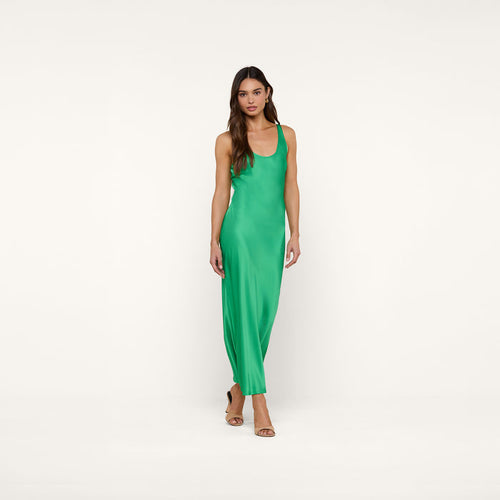 A woman wearing the Akiya Satin Maxi Dress in island green and tan heels stands against a plain white background, looking forward with a neutral expression.