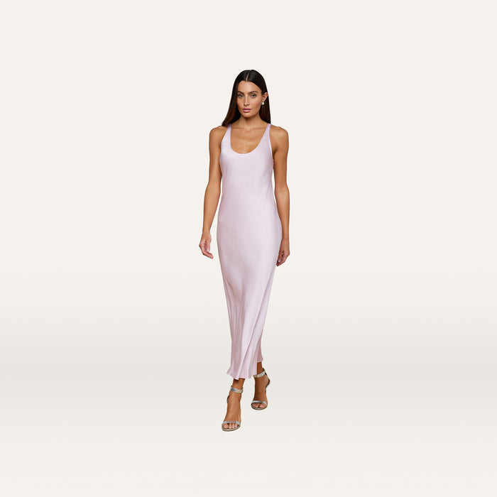 A woman wearing the Akiya Satin Maxi Dress in pastel lilac and strappy heels walks confidently against a plain white background.