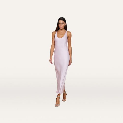 A woman wearing the Akiya Satin Maxi Dress in pastel lilac and strappy heels walks confidently against a plain white background.