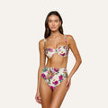 A woman wearing the Alexandria Bikini Top, a high-waisted bikini featuring rose leopard print and pink floral patterns with a balconette design, stands against a plain light background.