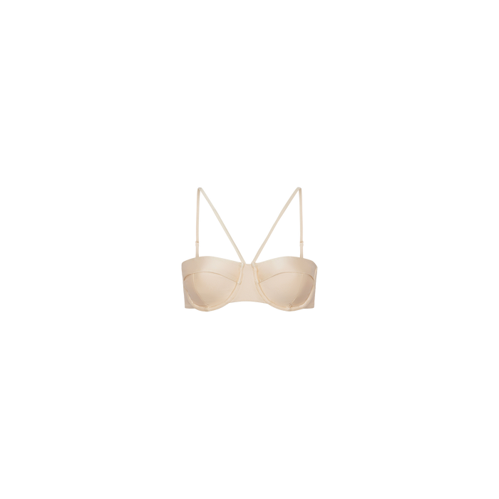 The Alexandria Bikini Top features a beige underwire design with thin adjustable straps, displayed against a plain white background.