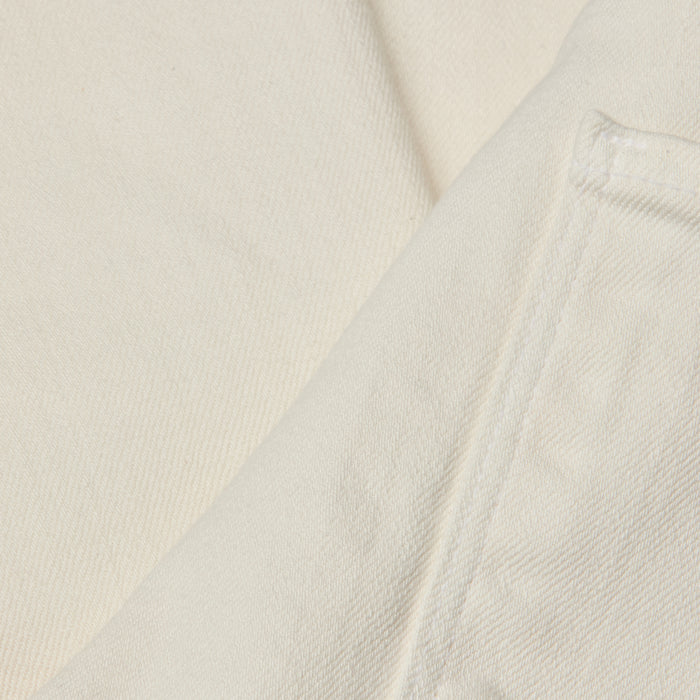Close-up of off-white or cream-colored denim fabric, highlighting a pocket and visible stitching details on the Alicent Wide-Leg Jean. The texture and weave of the high-rise, wide-leg jean’s fabric are clearly shown.