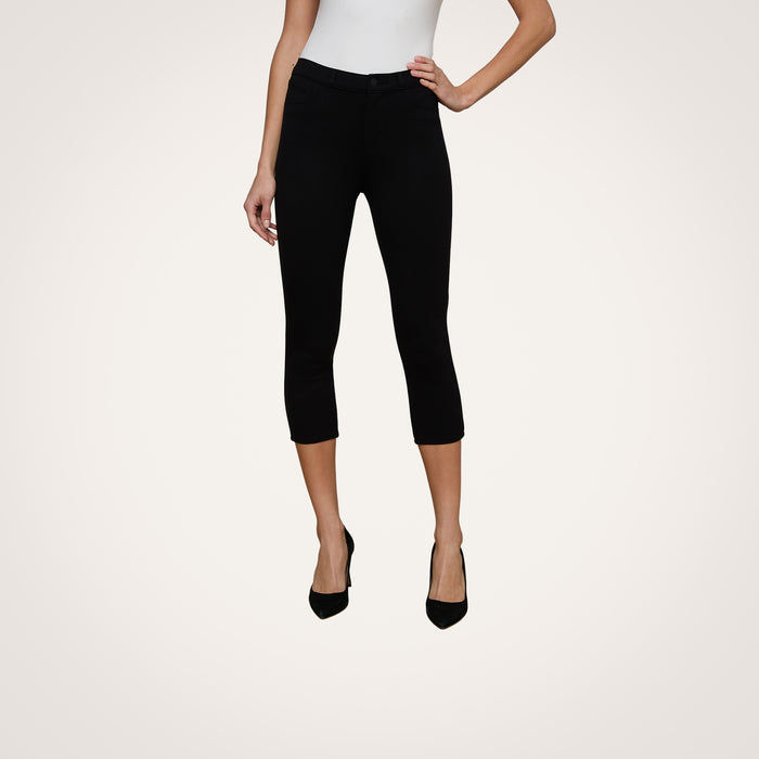 Wearing the Amaris Pedal Pusher in black, this woman pairs the body-hugging pants with a white sleeveless top and black heels. Only her body from shoulders down is shown against a plain light background.