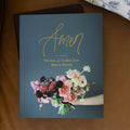 Amen from Eden to Eternity Matte Study Cover on a brown leather couch next to a white and blue decorated pillow
