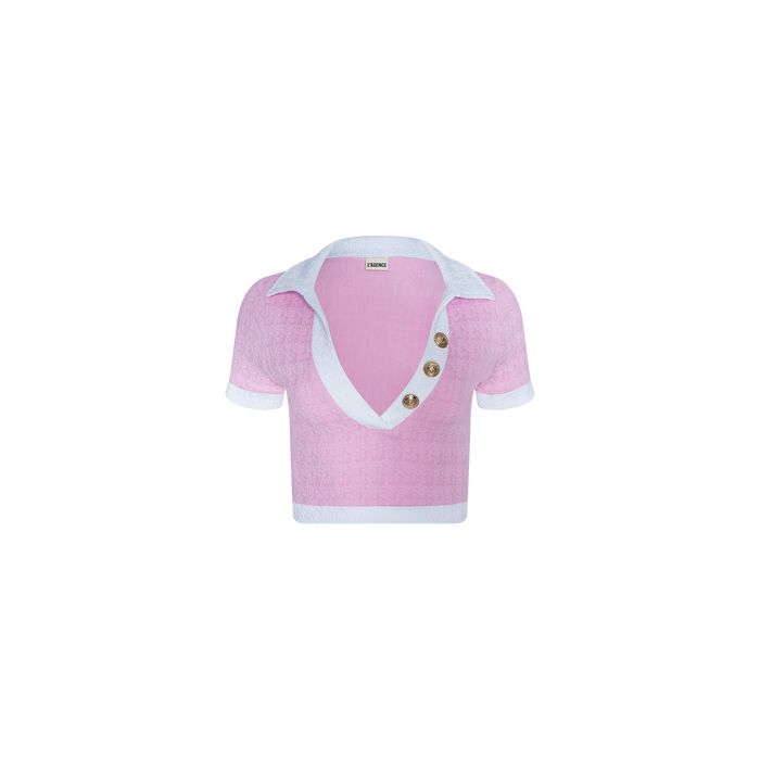 The Anastasia Cropped Rashguard is a pink short-sleeve polo top featuring a deep V-neck, white collar and cuffs, and three large buttons on the right side of the neckline. Crafted from water-safe bouclé fabric, it is displayed against a plain white background.