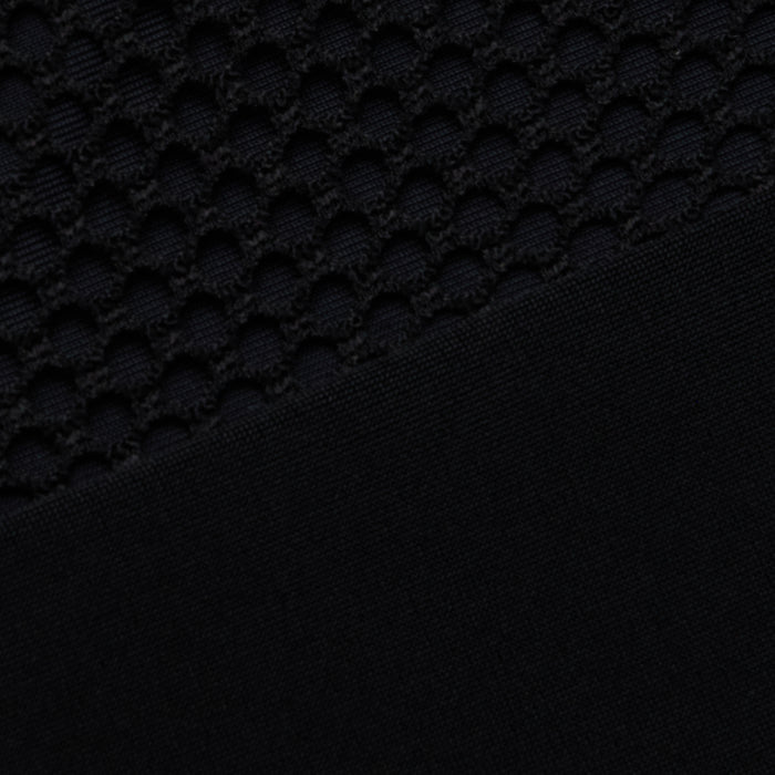 Close-up of the Anastasia Swim Top—a black polo-style top with a textured, honeycomb pattern on the upper half and a sleek, solid black finish on the lower half—perfect for showcasing beachside sophistication.