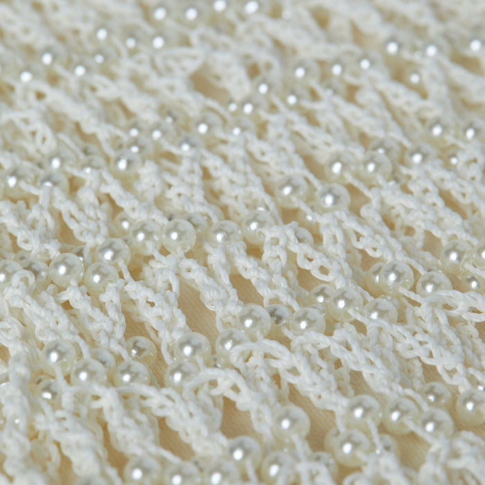 Close-up of the Angela Crochet Cover-Up Dress, featuring a white crocheted fabric with an open, lacy pattern, decorated with evenly spaced small, shiny faux pearl accents throughout the design.