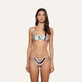 A woman stands facing forward against a plain light background, wearing the Annabelle Bikini Top, which features a colorful abstract swirl print with pink, blue, black, and white stripes in a triangle silhouette.