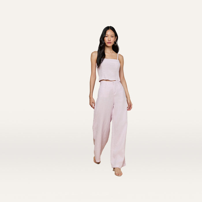 A woman wearing the Arlin Linen Tank in light pink paired with matching wide-leg pants walks forward against a plain white background.
