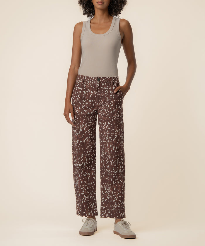 Woman wearing cocoa brown high-rise relaxed leg pants with white speckled pattern and cream sleeveless tank top.