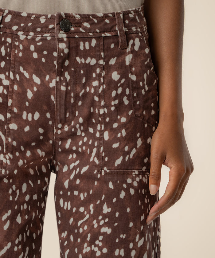 Brown relaxed-leg jeans with white abstract spots and high-rise waistband.