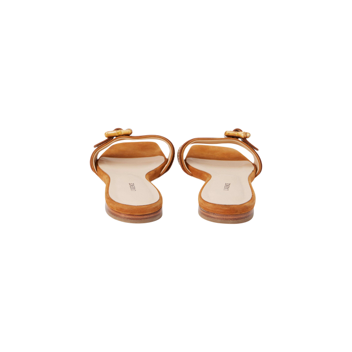 The Aurelie Buckle Sandal is a pair of tan brown, square-toed sandals featuring a single front strap and a distinctive bamboo buckle detail, shown from the back against a white background.