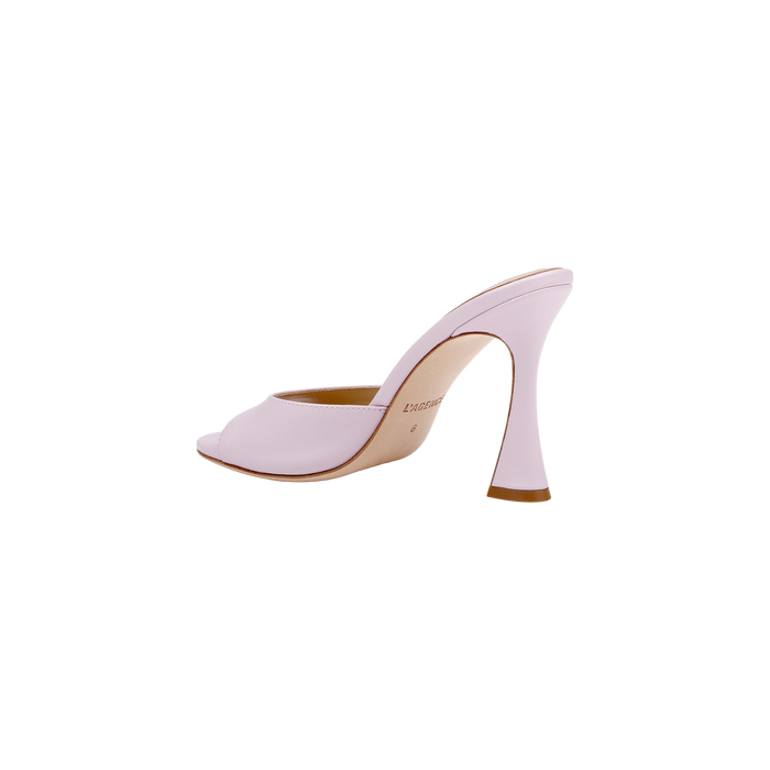 The Avery Leather Open-Toe Mule, crafted in pale pink leather, features an open toe and a sculpted, curved heel; it is displayed in profile against a white background.