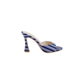 The Avery Open-Toe Mule showcases a blue striped denim upper with an open-toe silhouette and a distinctive curved stiletto heel, displayed against a plain white background.