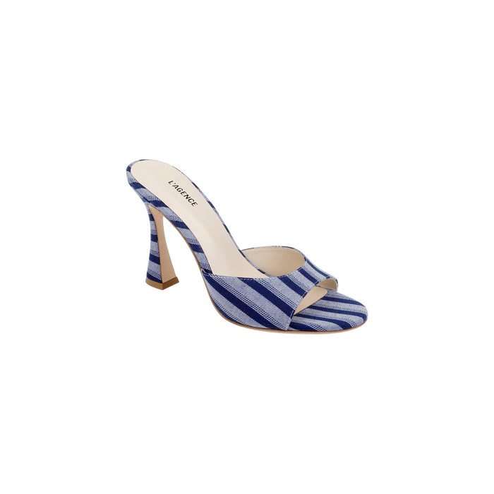 The Avery Open-Toe Mule is a blue striped denim high-heeled shoe featuring an open-toe design and a beige insole, displayed against a plain white background.