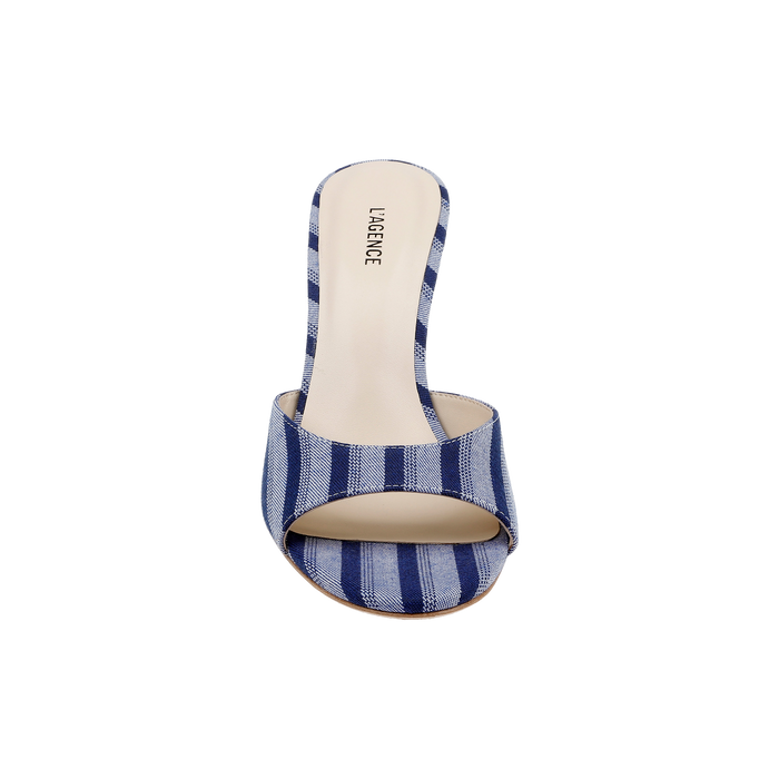 Introducing the Avery Open-Toe Mule: a blue striped denim heeled sandal featuring a flared heel, single wide strap, and beige insole stamped with the LAGENCE brand name. This modern mule boasts an elegant open-toe design for contemporary style.