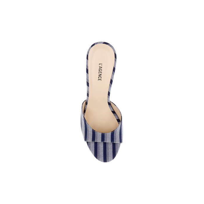 The Avery Open-Toe Mule is a single flared heel sandal with an open-toe design, showcasing blue striped denim and the LAGENCE brand name printed on the insole, viewed from above on a white background.