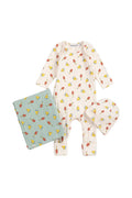 A baby clothing set laid flat on a light gray background, including a long-sleeve footless one-piece in warm off-white with a repeating yellow and red mushroom print, a folded pale blue quilted blanket with the same mushroom pattern, and a matching soft hat.
