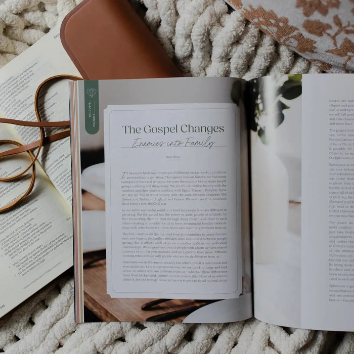Be Still Issue 36 Magazine opened to the Gospel changes enemies into friends page laying on an open bible on a white knitted blanket