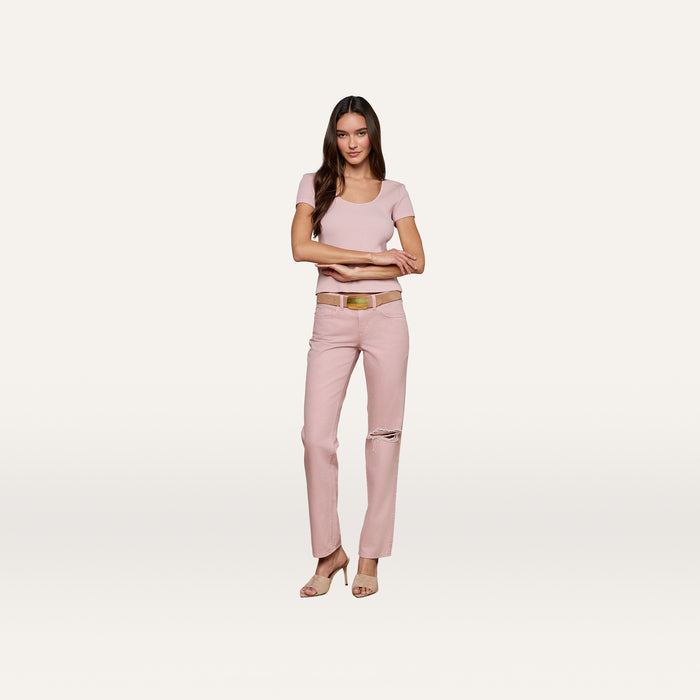 Woman standing with arms crossed, wearing the Brynlee Scoopneck Tee in light pink, paired with pink pants featuring a knee rip, a brown belt, and beige heels against a plain white background.