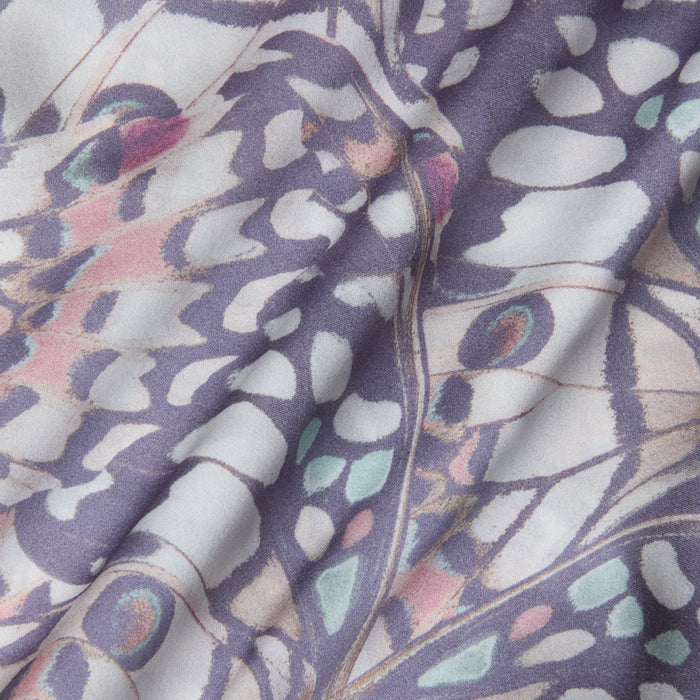 Close-up of the Calista Satin Camisole, softly draped and bias-cut, featuring a pastel butterfly wing print in shades of lavender, pink, blue, and white with abstract shapes and delicate lines.