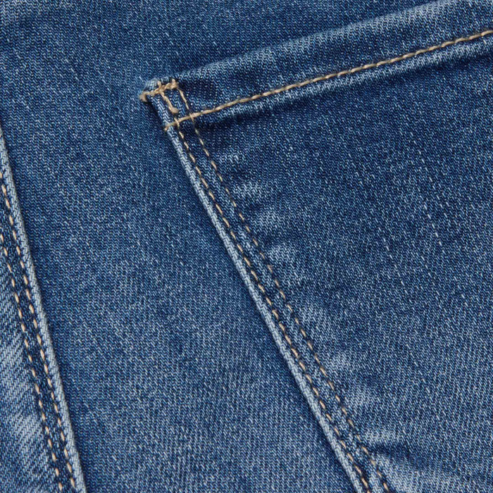 Close-up of blue stretch denim fabric on the Celestia Slim-Leg Jean, featuring a pocket with visible orange stitching that highlights the texture and detailed seams distinctive to this style.