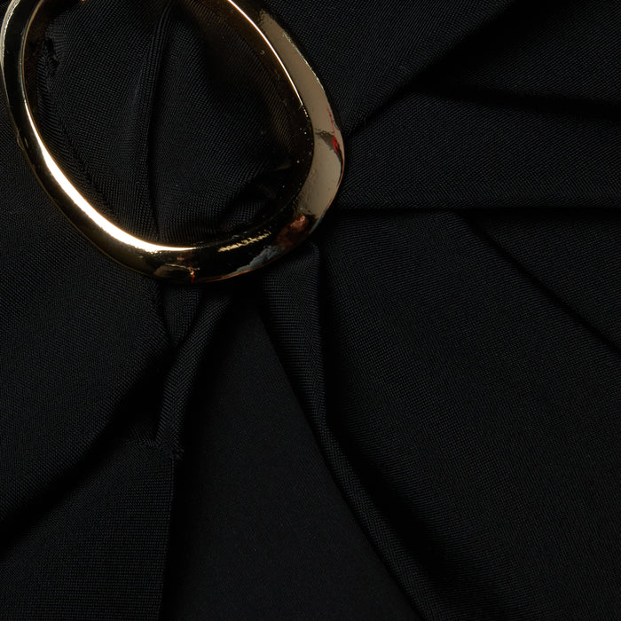 A close-up of the Chandra Cover-Up Skirt features black fabric elegantly gathered and secured with gold hardware, adding a touch of poolside glam.