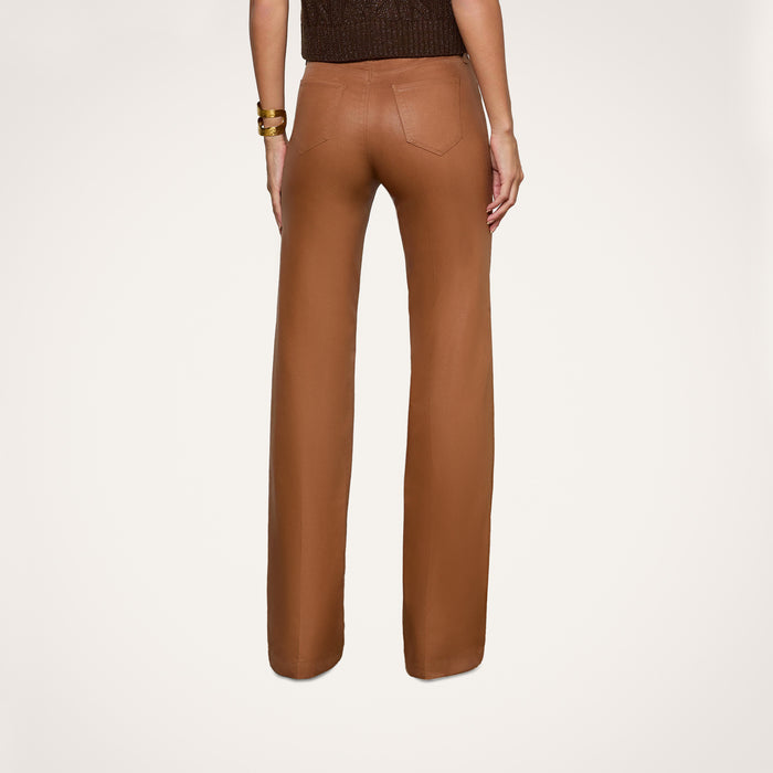 A person is shown from the back against a plain white background, wearing the Clayton Coated Wide-Leg Jean featuring a contoured waistband and styled with a sleeveless top.