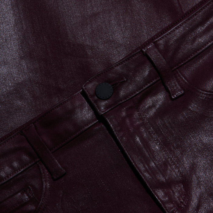Close-up of shiny, dark burgundy metallic pants showing the waistband, belt loops, button, and part of the front pocket. The glossy fabric has a striking finish.
