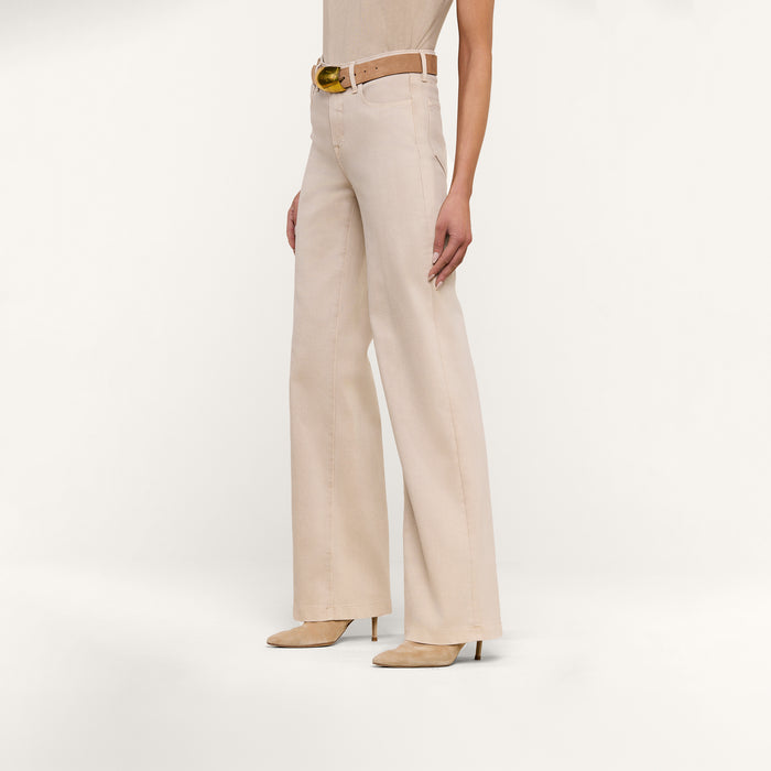Model showcases the Clayton Wide-Leg Jean with its high-waisted fit, matching belt, and heeled shoes, standing against a plain white background. Only the lower half of the body is visible.