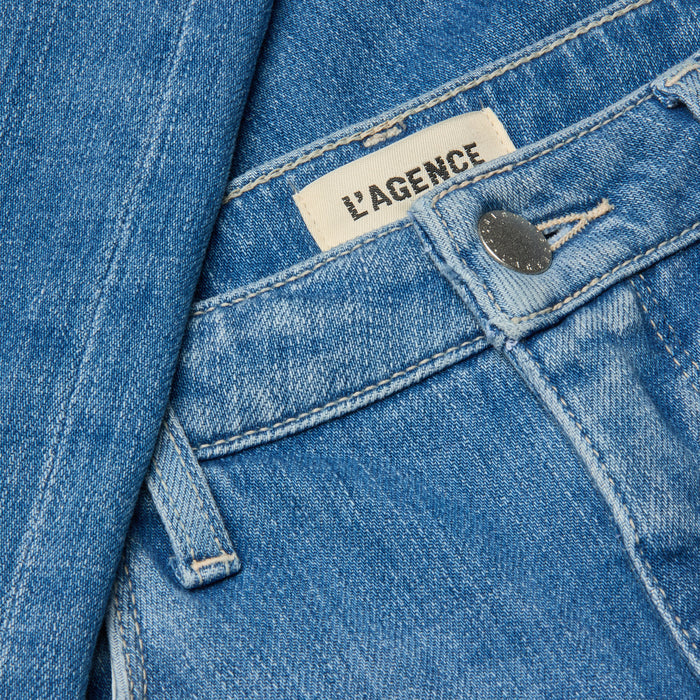 Close-up of the Clayton Wide-Leg Jean in blue denim, featuring a silver button, visible LAGENCE brand label, detailed stitching, and high rise stretch denim fabric.