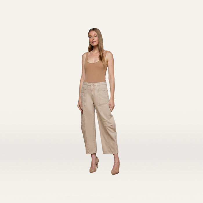 A woman stands against a plain white background wearing a tan sleeveless top, nude heels, and the Cody Cropped Barrel-Leg Jean in beige with wide legs and patch pockets.