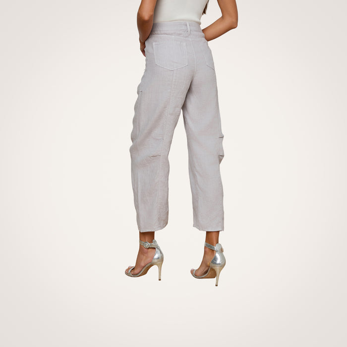 Woman wearing the Cody Cropped Linen Pant, high-waisted with a lightweight barrel-leg silhouette, paired with silver high heels and standing with her back to the camera against a plain light background.