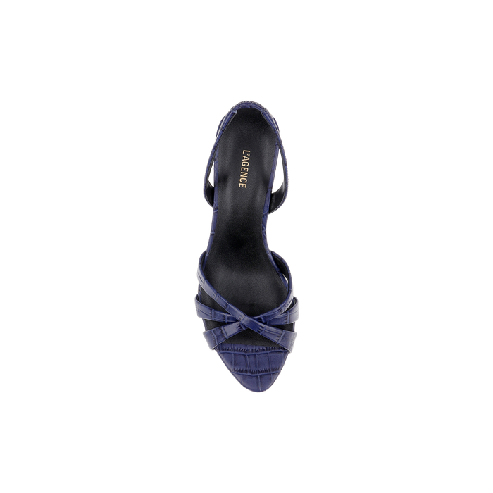 Top view of a single Colwill Slingback Sandal in navy blue, featuring a pointed toe, crisscrossed straps, and a croc-embossed pattern. The insole displays the LAGENCE brand name printed in gold. The background is plain white.