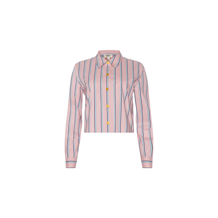 The Cosette Shirt is a pink, long-sleeve tailored shirt with blue and white vertical stripes and yellow buttons, crafted from an organic cotton-blend fabric. Featuring a cropped high-low hem, this top is showcased against a plain white background.