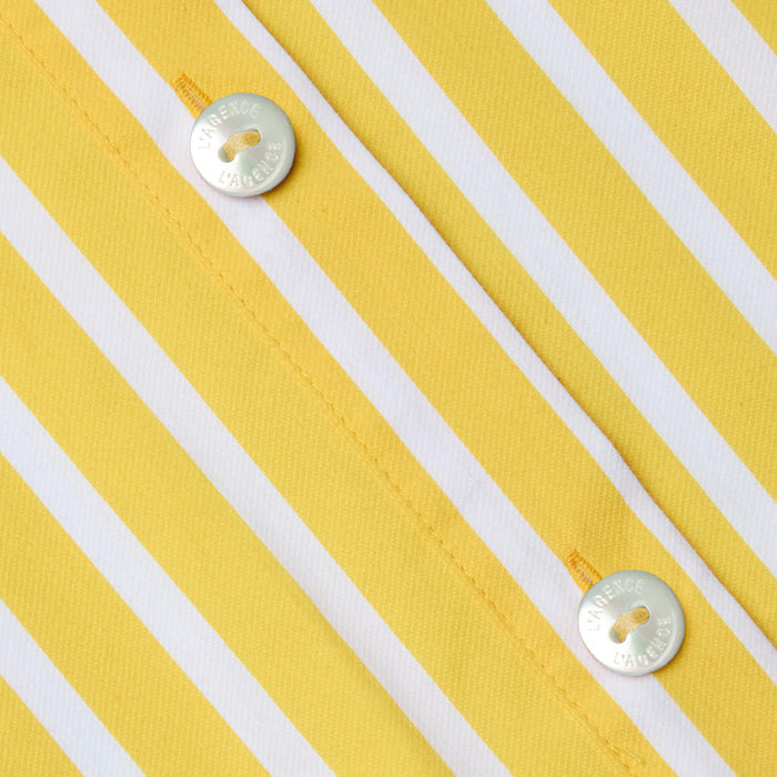 Close-up of the Cosette Shirt, a tailored piece made from organic cotton in yellow and white vertical stripes, featuring two shiny silver buttons engraved with text and sewn on with yellow thread.
