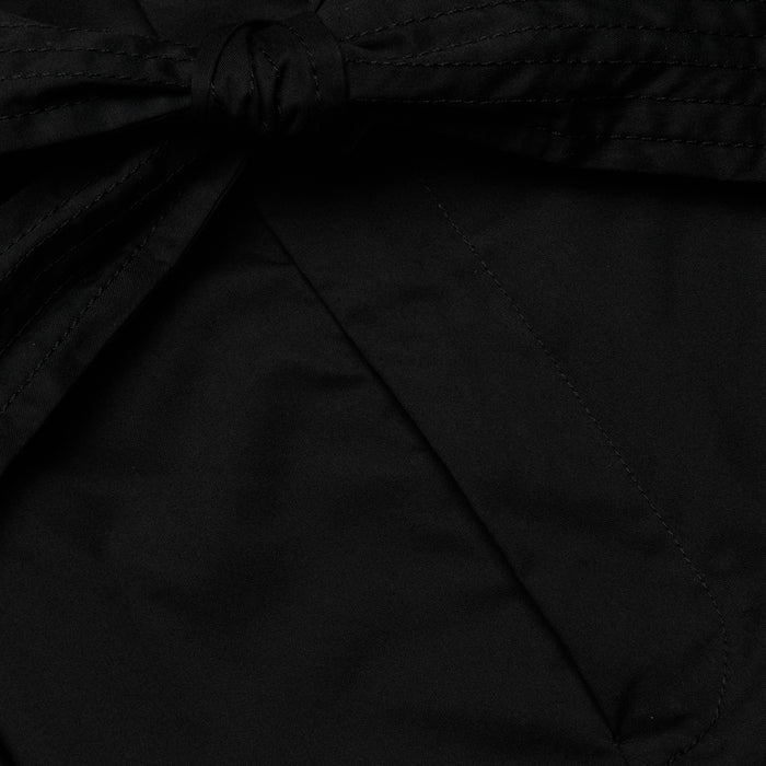 Close-up of the Damira Poplin Short in black stretch poplin fabric, featuring a tied self-tie belt bow knot. The smooth and slightly shiny material suggests a polished finish, ideal for a chic look.