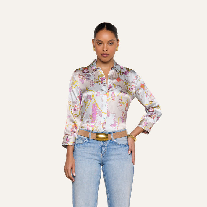 A woman wearing the Dani Silk Blouse paired with light blue jeans and a beige belt stands against a plain light background, looking directly at the camera with a neutral expression.