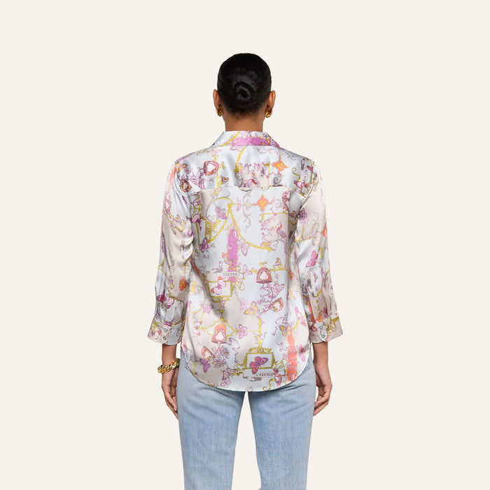 A person with short hair, wearing the Dani Silk Blouse in a pastel pattern with three-quarter sleeves and light blue jeans, is seen from the back against a plain off-white background.