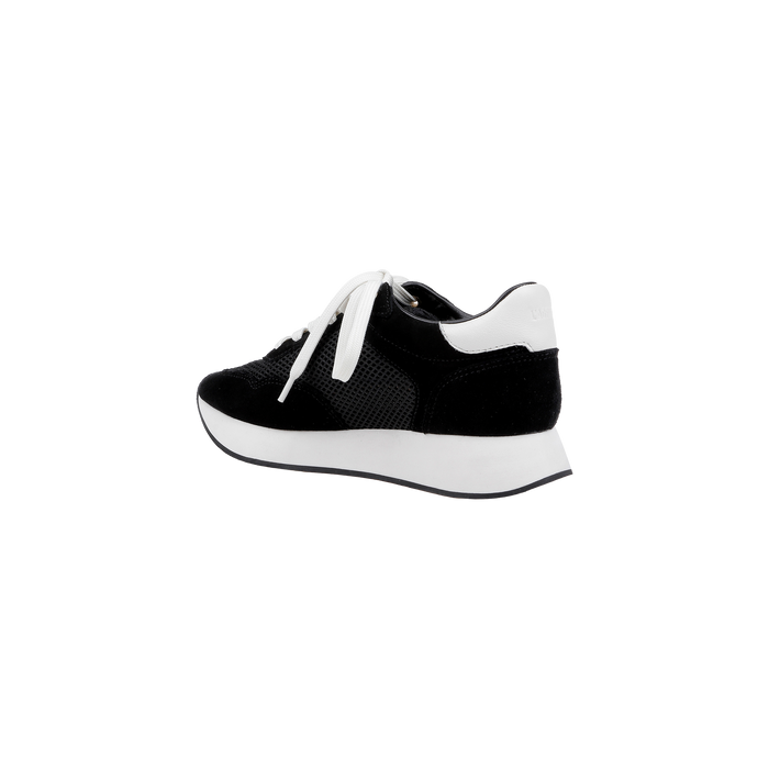 The Deepa Platform Sneaker, shown from a side angle on a plain white background, features black and white coloring with white laces, a thick white sole, a black suede finish, and a comfortable memory foam insole.