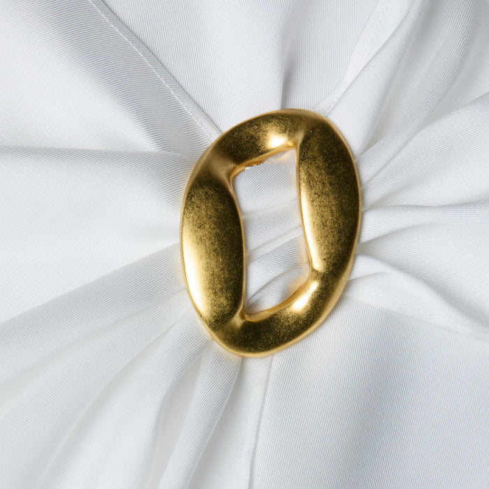 A close-up of the Driselle Scarf Top shows white satin fabric gathered at the center with a shiny, irregularly-shaped gold buckle accent, creating soft, elegant folds that radiate outward.