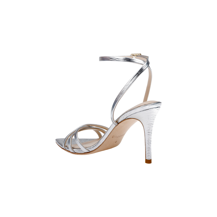 Dua Leather Sandal in metallic silver features a lizard-embossed finish, thin strappy stiletto heel design, adjustable ankle strap with buckle closure, memory foam insole for added comfort, beige sole, and an open toe.