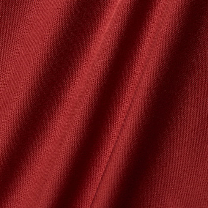 Close-up of the Eddie Tank in poppy red, showcasing its smooth, bias-cut satin fabric with soft folds and diagonal lines created by gentle draping. The texture appears soft and slightly shiny, highlighting the richness of the color.