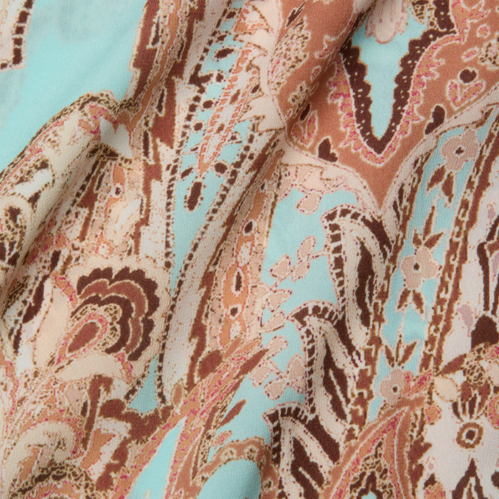 A close-up of the Elise Cover-Up Dress, crafted from water-safe crepe fabric with an intricate paisley print in shades of brown, pink, and turquoise, featuring flowing shapes and detailed floral designs.